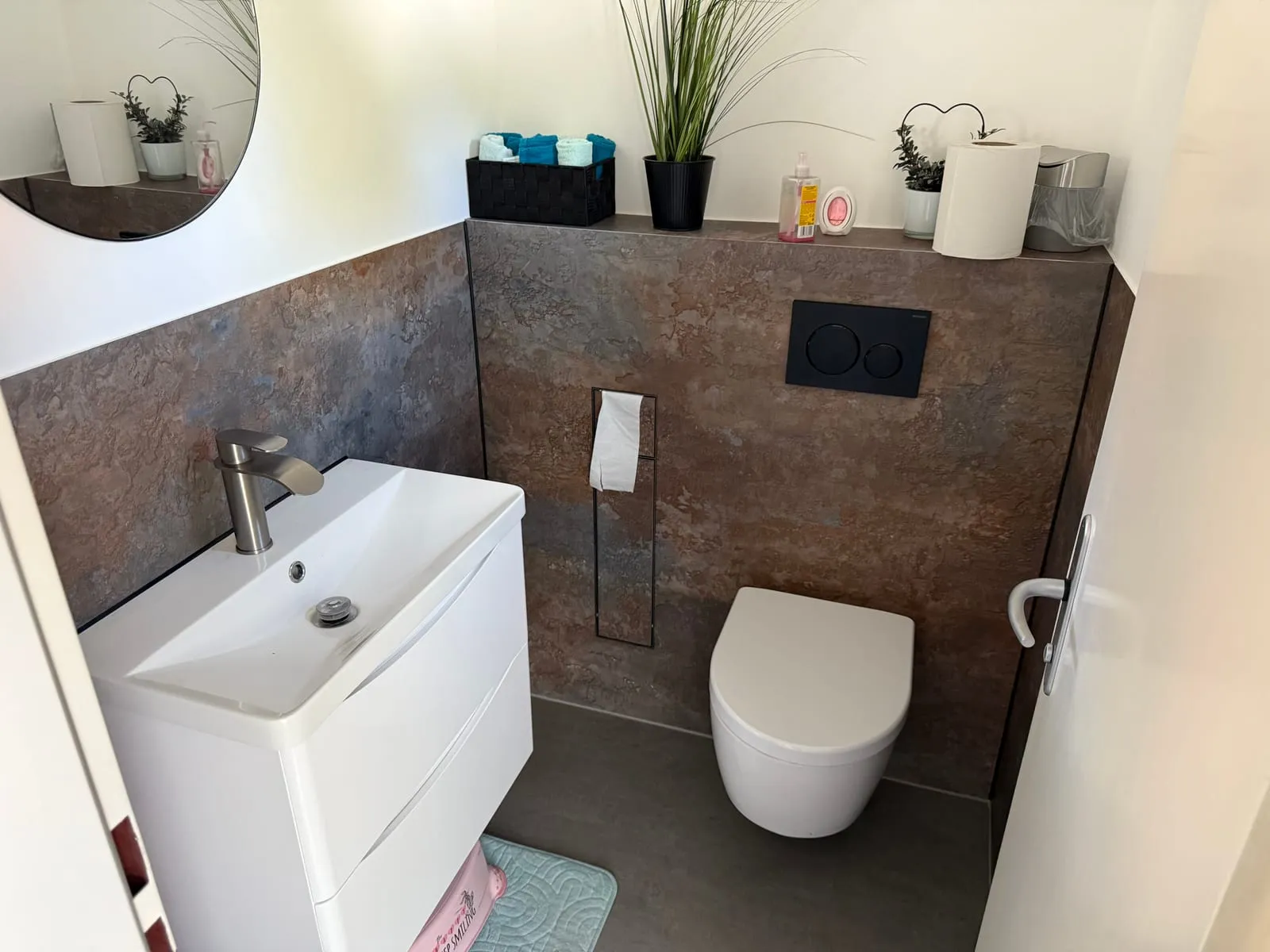 Gäste-WC mit fugenloser Wand in warmer Bronze-Optik